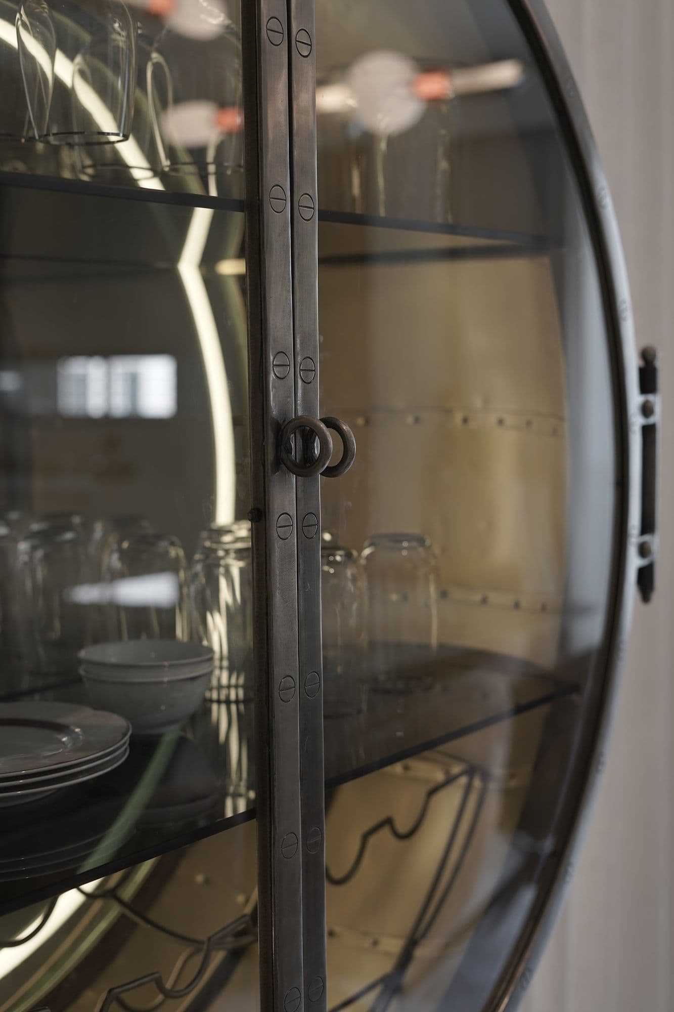 Detail of an OSIMIRI display cabinet in brass, glass, and wood showing material craftsmanship